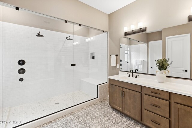 full bath with a stall shower, vanity, and tile patterned floors