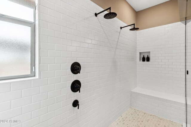 full bath with a healthy amount of sunlight and tiled shower