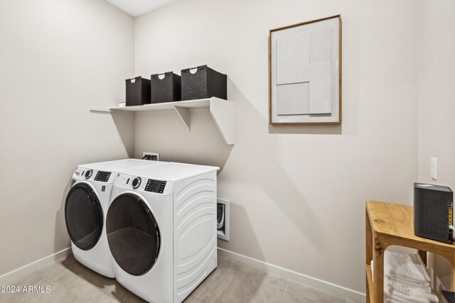 clothes washing area featuring laundry area, washing machine and dryer, and baseboards