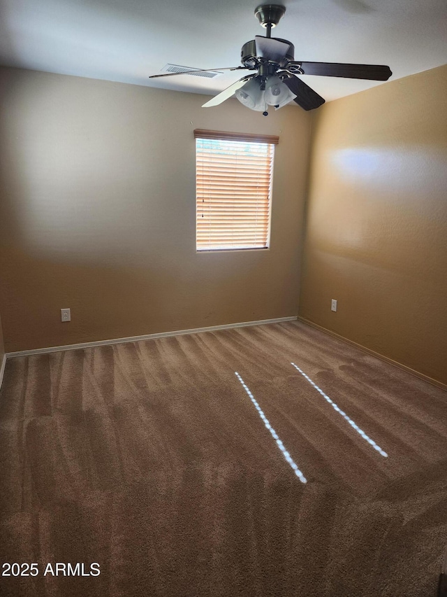 empty room featuring ceiling fan and carpet