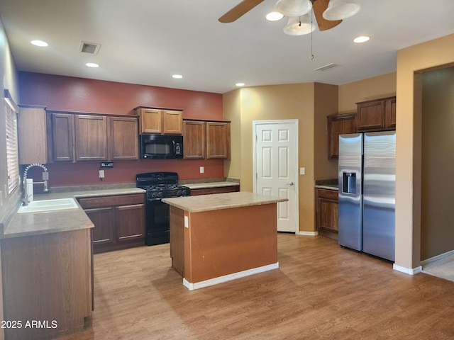 kitchen featuring a kitchen island, sink, ceiling fan, black appliances, and light wood-type flooring