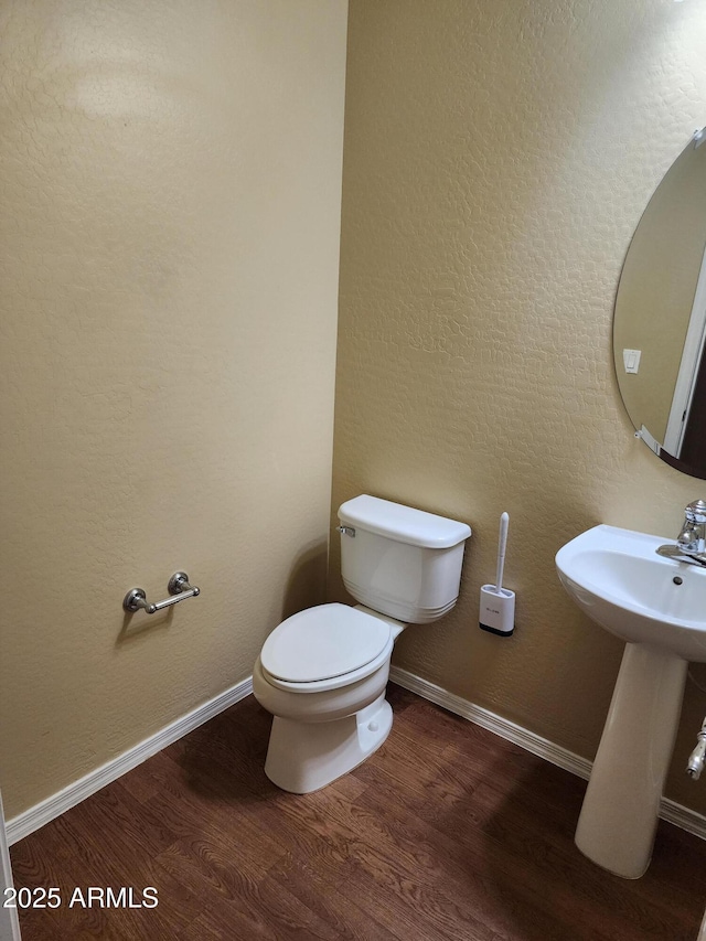 bathroom with hardwood / wood-style floors, sink, and toilet