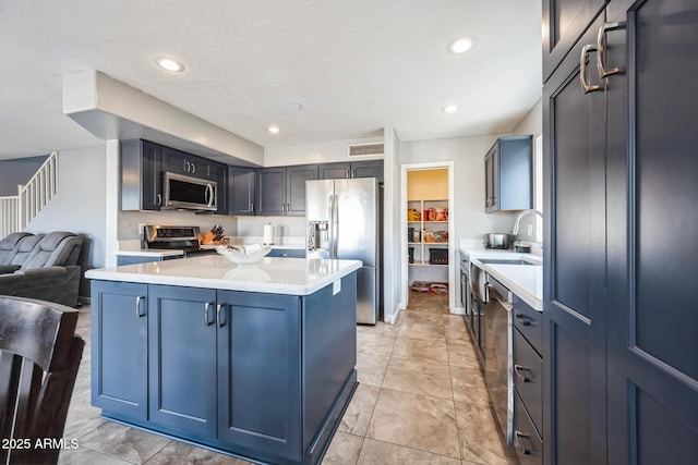 kitchen featuring a textured ceiling, appliances with stainless steel finishes, and a center island