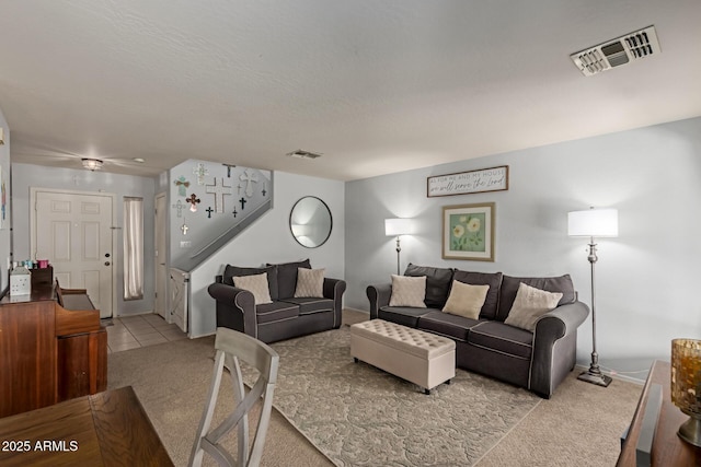 tiled living area with carpet, visible vents, and baseboards