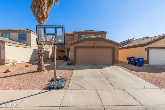 view of front of home with concrete driveway, a tiled roof, a garage, and stucco siding