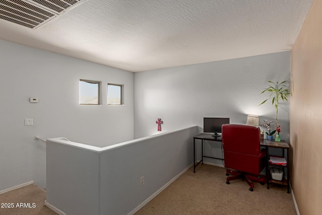carpeted office featuring visible vents and baseboards