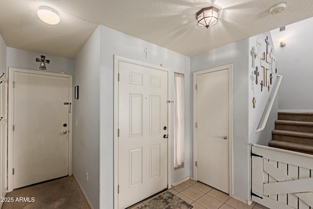 entrance foyer featuring light tile patterned floors, baseboards, and stairs