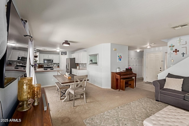 living area with visible vents and light colored carpet