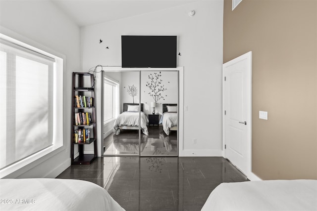 bedroom featuring baseboards and a towering ceiling