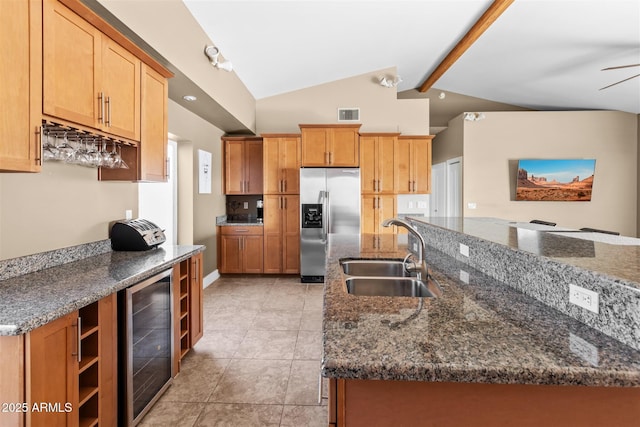 kitchen featuring a sink, stainless steel fridge with ice dispenser, wine cooler, dark stone counters, and light tile patterned floors