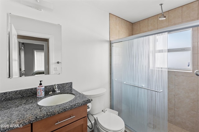 full bath featuring a stall shower, vanity, and toilet