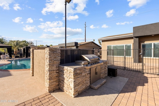 view of patio / terrace featuring exterior kitchen, grilling area, and fence