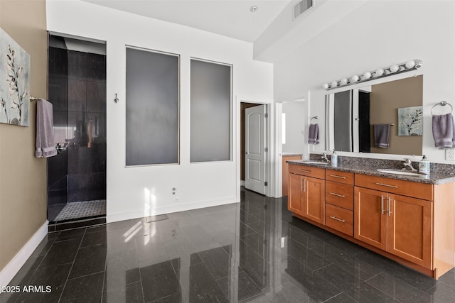 full bath with granite floors, baseboards, double vanity, and a shower stall