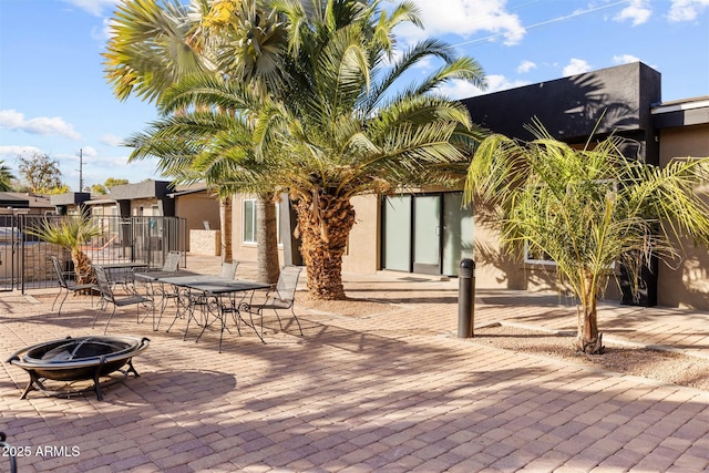 view of patio featuring a fire pit and fence