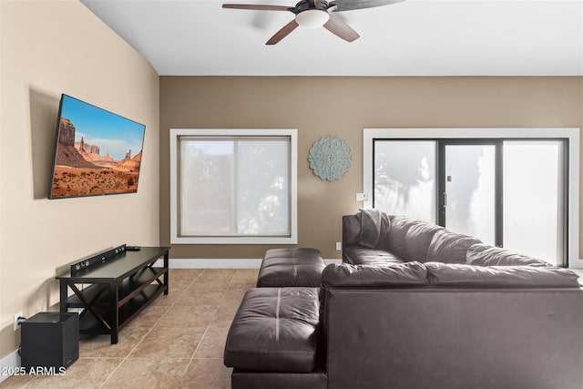 living area featuring ceiling fan and baseboards