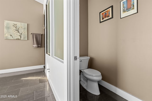 bathroom with baseboards and toilet