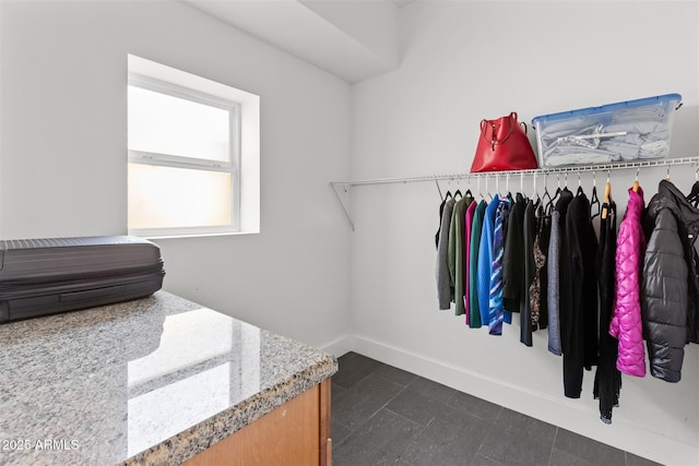 walk in closet with dark tile patterned flooring
