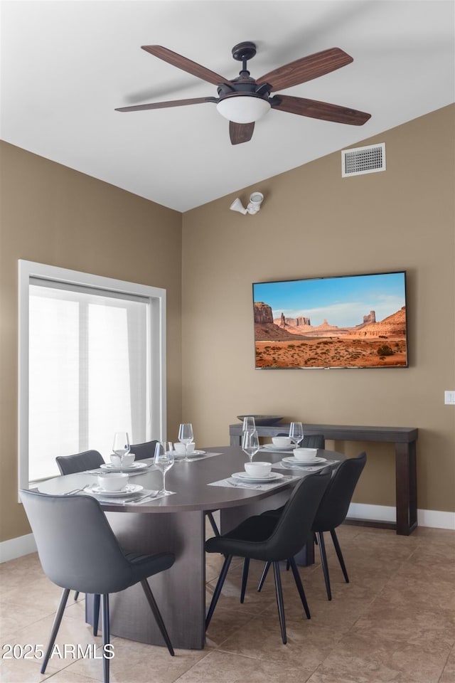 dining space with a ceiling fan and baseboards