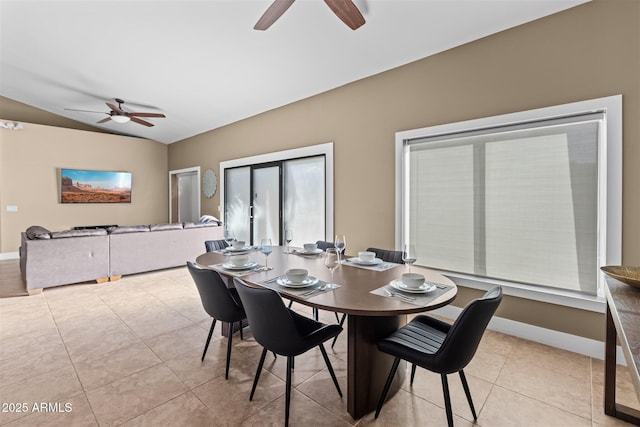 dining area with ceiling fan, vaulted ceiling, tile patterned flooring, and baseboards