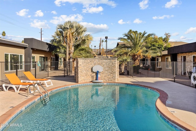 community pool with a patio and fence