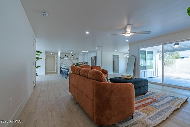 living room featuring ceiling fan and light wood-type flooring