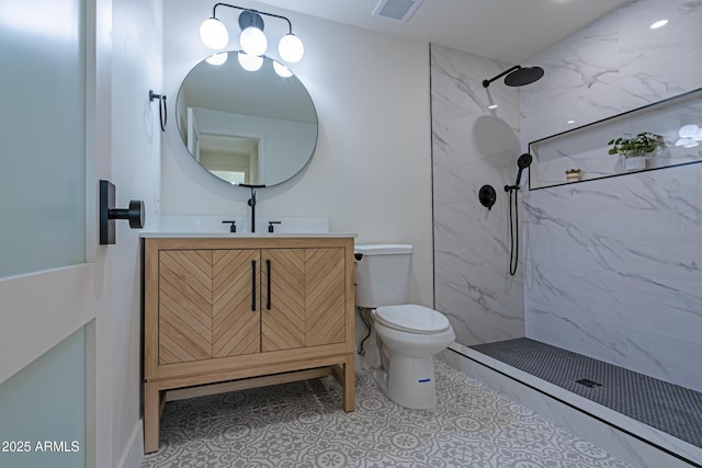 bathroom with vanity, toilet, and a tile shower