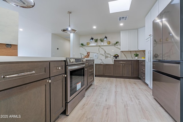 kitchen with dark brown cabinetry, hanging light fixtures, stainless steel appliances, and white cabinets