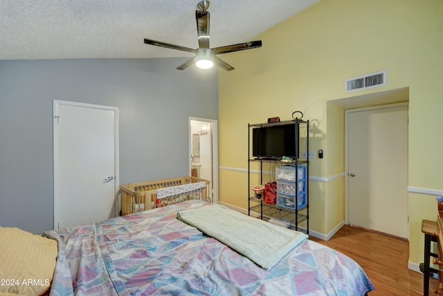 bedroom with wood-type flooring, a textured ceiling, ensuite bathroom, and ceiling fan