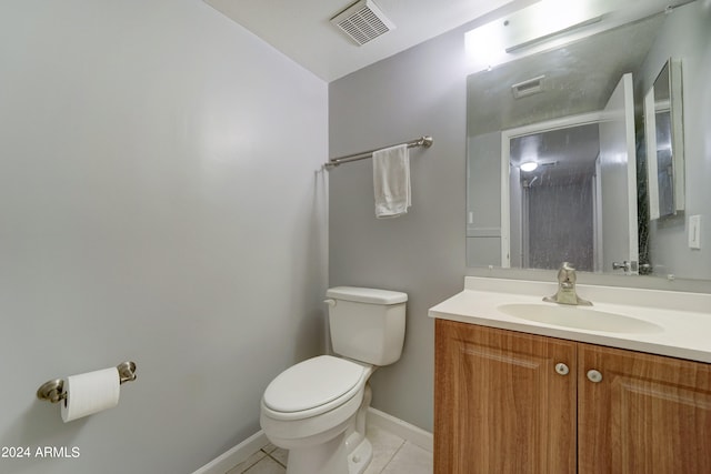 bathroom with toilet, vanity, and tile patterned floors