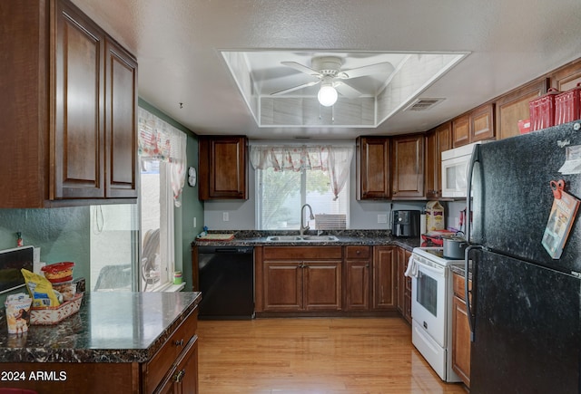 kitchen with dark stone counters, ceiling fan, sink, black appliances, and light hardwood / wood-style flooring