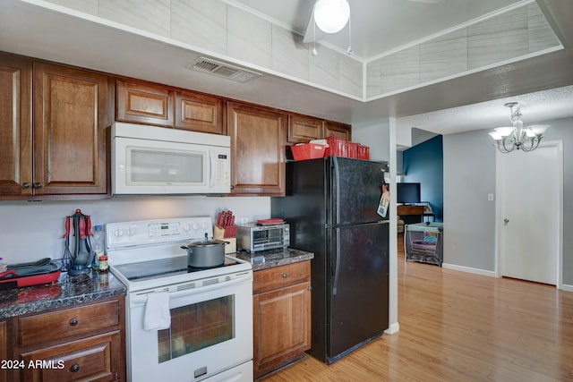 kitchen featuring light wood-type flooring, white appliances, an inviting chandelier, and dark stone countertops