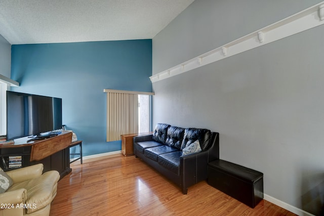 living room featuring hardwood / wood-style floors and high vaulted ceiling