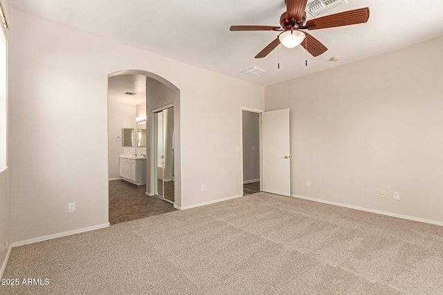 17493 N Costa Brava Ave, Maricopa, AZ 85139 - unfurnished bedroom featuring arched walkways, carpet floors, and ensuite bathroom
