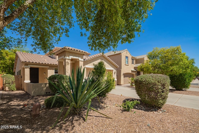 17493 N Costa Brava Ave, Maricopa, AZ 85139 - view of front facade with stucco siding, a tiled roof, driveway, and a garage