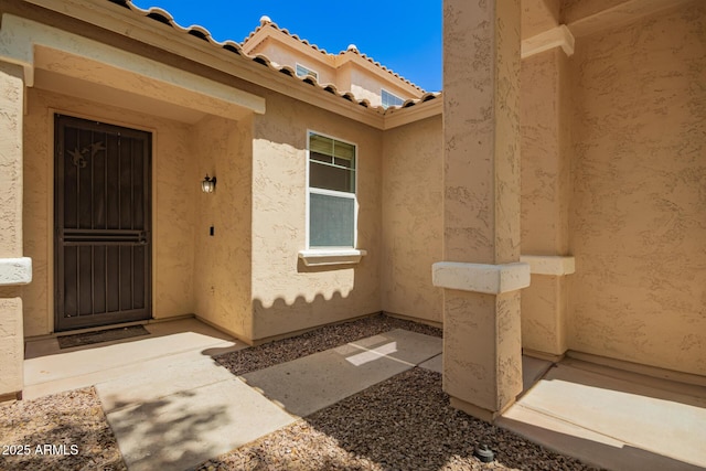 17493 N Costa Brava Ave, Maricopa, AZ 85139 - view of exterior entry with stucco siding and a tile roof