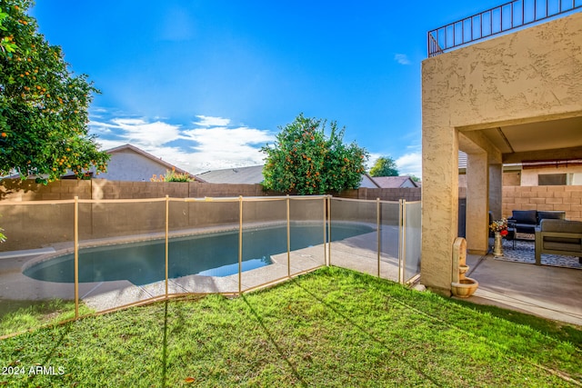 view of pool with a patio and a lawn