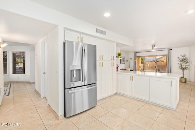 kitchen featuring white cabinetry, light tile patterned flooring, kitchen peninsula, and stainless steel fridge