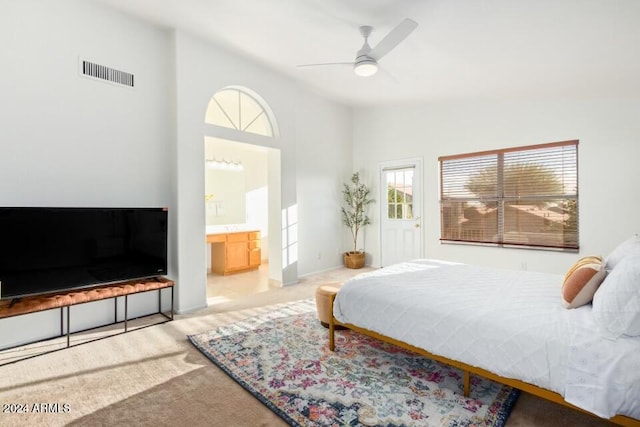 bedroom featuring ceiling fan, high vaulted ceiling, light carpet, and ensuite bathroom