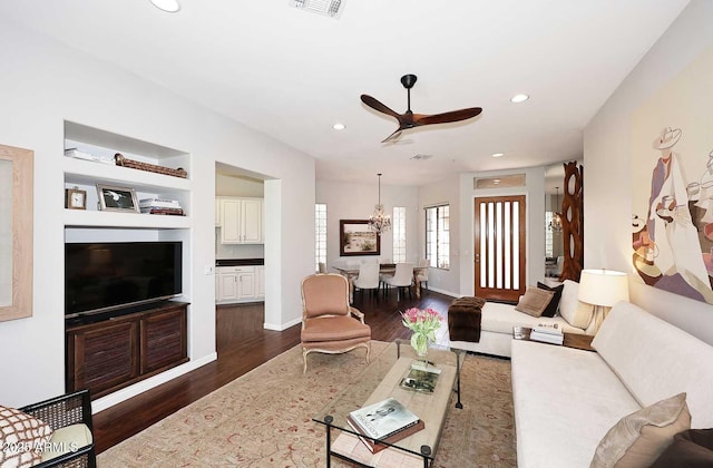 living room featuring dark wood-style floors, recessed lighting, baseboards, and ceiling fan with notable chandelier