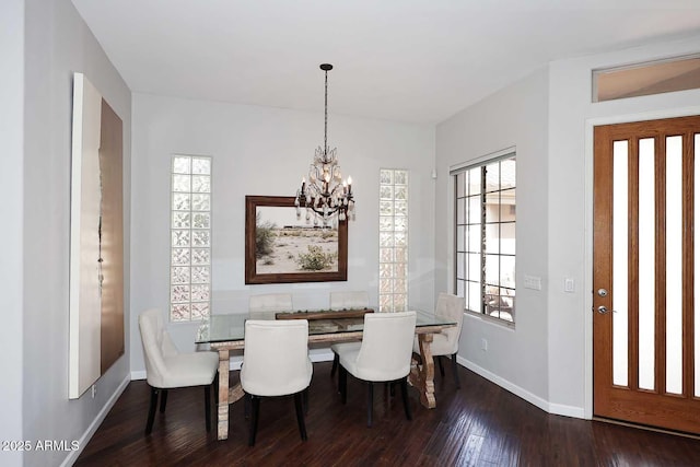 dining room featuring hardwood / wood-style flooring, baseboards, and a notable chandelier