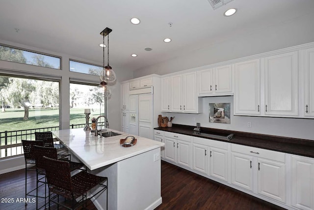 kitchen featuring dark wood-style flooring, white cabinetry, and a sink