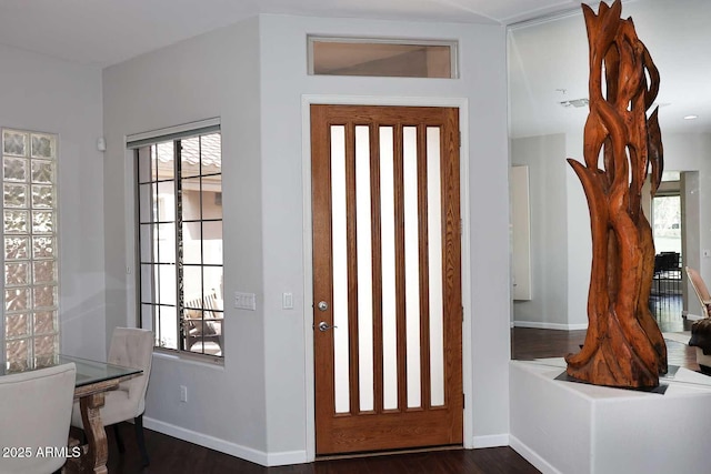 foyer featuring visible vents, dark wood finished floors, and baseboards