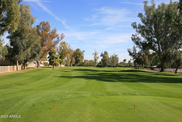 view of community with view of golf course and a yard