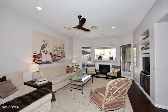 living area with recessed lighting, a healthy amount of sunlight, visible vents, and a fireplace