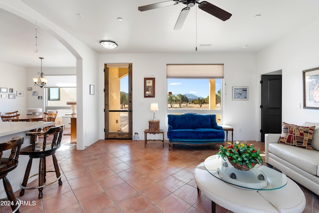 living room featuring tile patterned flooring and ceiling fan with notable chandelier