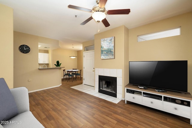 11375 E Sahuaro Dr Unit 1055, Scottsdale, AZ 85259 - living room featuring wood finished floors, a ceiling fan, and a fireplace