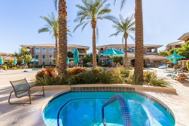 view of pool with a patio area and a hot tub