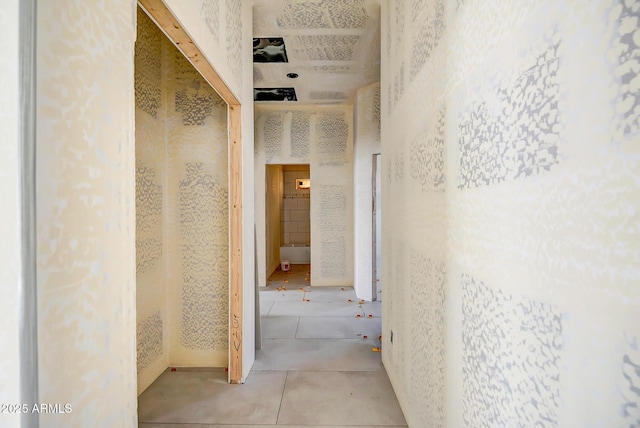 hallway with wallpapered walls and tile patterned floors