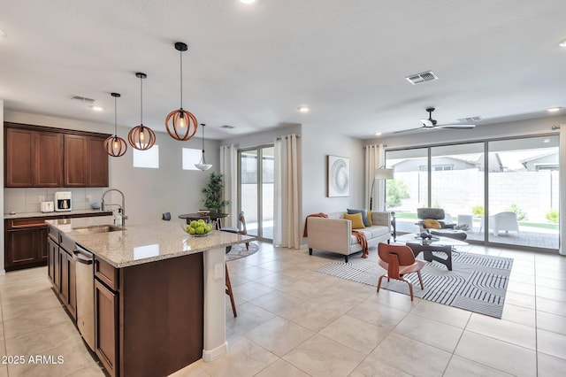 19908 W Montecito Ave, Litchfield Park, AZ 85340 - kitchen with plenty of natural light, open floor plan, light stone countertops, a center island with sink, and recessed lighting