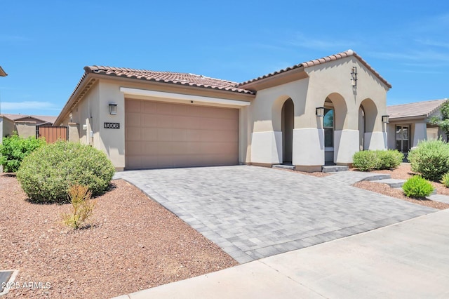 19908 W Montecito Ave, Litchfield Park, AZ 85340 - mediterranean / spanish-style home featuring stucco siding, decorative driveway, an attached garage, and a tile roof